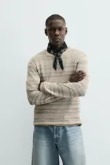 Camiseta de manga larga con cuello redondo y ajuste relajado, confeccionada en tejido de punto con estructura abierta y patrón de rayas horizontales.