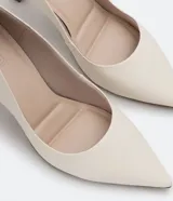 Zapato scarpin color blanco hueso, con puntera fina y taco fino diferenciado de 8 cm de altura. Fabricado en poliuretano.