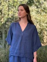 Blusa azul marino de lino, con cuello camisero que forma un escote en V, mangas cortas dobladas y calce holgado.