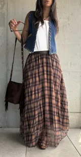 Falda larga plisada con estampado de cuadros en tonos camel y marrón, confeccionada en tejido liviano con cintura elástica.