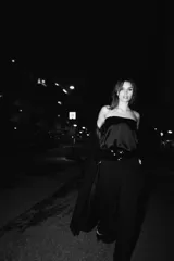 Top strapless de tejido satinado color negro, con diseño de escote recto y hombros descubiertos. Presenta bandas de lentejuelas a tono en el borde superior e inferior, y cierre lateral con cremallera oculta.