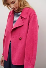 Chaqueta de paño color fucsia, con solapas clásicas y cierre frontal mediante un alamar. Presenta un corte recto y mangas largas, ideal para un estilo sofisticado y abrigado.