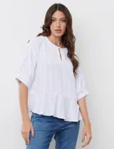 Blusa blanca de gasa marca Zac & Rachel, con cuello a la base con apertura ojal y botón. Manga amplia con detalles en punto smock.