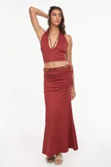 Top halter color bordó con escote profundo y tirantes decorados con cuentas artesanales.