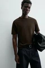 Camiseta de corte relajado (relaxed fit) color blanco roto o crema, con cuello redondo y manga corta.