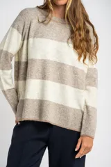 Sweater de punto con diseño de rayas horizontales anchas en color bordó y beige. Presenta cuello redondo con detalle de lurex, mangas largas y puños y ruedo acanalados.