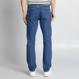 Pantalón de jean de corte recto, color azul medio, con bolsillos delanteros y traseros.