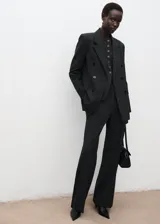 Chaqueta sastre gris oscuro con doble botonadura, cuello con solapa de muesca, bolsillos laterales con solapa y manga larga.