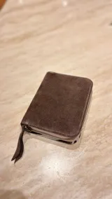 Billetera de cuero de pelo con estampado animal print de leopardo. Cuenta con cierre perimetral y una etiqueta de cuero con el logo de la marca grabado.