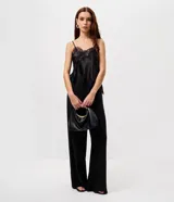 Pantalón de sastrería modelo pantalona, de corte amplio y tiro alto, con cintura lisa y pliegues frontales. Confeccionado en tejido de poliéster con elastano.
