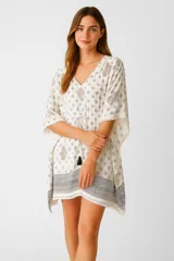 Túnica de algodón color crema con estampado de mandalas en tonos grises y azules. Tiene escote en V, mangas cortas amplias, cordón ajustable en la cintura con borlas y flecos en el ruedo.