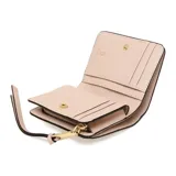 Billetera compacta de cuero color gris claro con interior rosa pálido. Tiene cierre de cremallera, correa de muñeca y aplique metálico dorado con el logo de la marca.