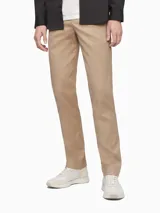 Pantalón de vestir color beige, corte slim, confeccionado en mezcla de algodón elástico. Presenta cierre de botón y cremallera, bolsillos delanteros y traseros.