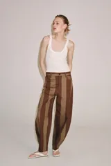 Jeans de tiro alto con diseño tapered y cinco bolsillos, con estampado de rayas verticales a contraste en tonos marrón y tostado. Cierre frontal con cremallera y botón.