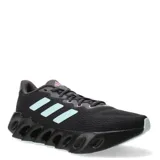 Championes de running Adidas Switch Run para mujer, en color negro con detalles en celeste y lila. Presentan una parte superior de malla transpirable y una entresuela de EVA con diseño de rebajes característico, ofreciendo estabilidad y amortiguación.