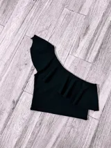 Top corto con un solo hombro y volado grande.