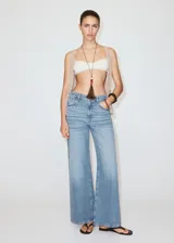 Jeans de denim celestes de tiro medio, diseño de corte recto y amplio con detalles de tachuelas en los bolsillos delanteros.