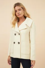 Chaquetón de lana fina sin teñir, con diseño de doble botonadura, solapas anchas y dos bolsillos frontales de parche. Cuenta con forro al tono.