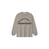Remera manga larga Fear of God Essentials de corte holgado y cuello redondo, en color gris topo. Presenta un estampado gráfico en el frente con el texto "Fear of God" en la parte superior y "Essentials" en cursiva grande.
