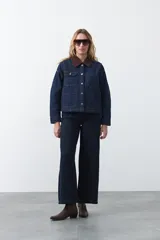 Jean de corte amplio y tiro medio, con diseño de costuras verticales frontales y bolsillos laterales tipo parche. Presenta un acabado en tono azul clásico.