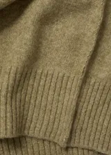 Vestido largo de punto con diseño recto, cuello redondo y manga larga con puños en canalé. Presenta una textura suave y un corte holgado.