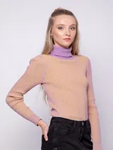 Polera de punto a rayas verticales en tonos gris plata y negro, de cuello alto y manga larga.