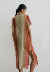 Vestido midi de red con estampa degradé en tonos naranja, beige y verde. Tiene tajos a los costados.