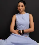 Vestido midi evasé de la marca Cortelle, confeccionado en bengalina de algodón con elastano. Presenta cuello redondo, diseño sin mangas con breteles anchos y cierre trasero mediante cremallera.