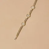 Pulsera de diseño articulado que combina eslabones de plata trenzada con detalles en oro y piezas circulares de nácar engarzadas.