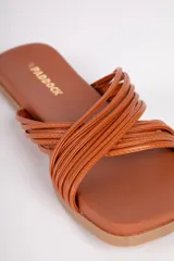 Sandalias bajas color suela, con tiras finas cruzadas de símil cuero.