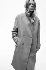 Abrigo cruzado de lana hasta la rodilla, con solapas de muesca, cierre de doble botonadura frontal y bolsillos insertados. Presenta trabillas con botón en los puños y abertura posterior, completamente forrado.