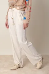 Pantalón ancho negro de lino y rayón, con cintura elastizada ajustable con cordón y bolsillos laterales.