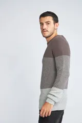 Sweater de punto con diseño color block en tonos azul marino y gris jaspeado. Presenta cuello redondo, mangas largas y un ajuste regular.