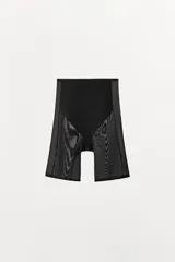 Shorts tipo ciclista de tiro alto con cintura elástica, confeccionado en poliamida con paneles laterales y frontales de tejido mesh. Presenta un diseño con efecto reductor que estiliza la figura.