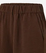 Short femenino Marfinno confeccionado en tejido airflow color marrón, de corte holgado, con cintura elástica y bolsillos delanteros.