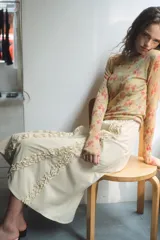 Top de punto fino con estampado floral, cuello redondo y manga larga.