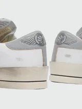 Championes Golden Goose modelo Stardan, color blanco con estrella negra de cuero texturizado en el lateral, detalles en gris y suela color crema con efecto desgastado.