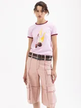 Remera de algodón pima orgánico color rosa, con cuello redondo y bordes de mangas en color bordó. Presenta un estampado frontal de cerezas con llamas.