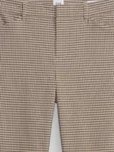 Pantalon de vestir de corte ajustado y tiro medio, con estampado de cuadros pequeños en tonos neutros. Cuenta con bolsillos laterales y cierre frontal.