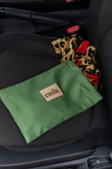 Neceser tipo sobre color verde militar con cierre superior y parche de cuero con el logo de la marca Cada.