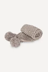 Bufanda tejida a mano en punto arroz color crudo, con detalle de pompón en uno de los extremos.