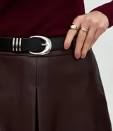 Short de tiro medio confeccionado en poliuretano con acabado que imita el cuero, de corte recto y diseño minimalista. Incluye un cinturón ajustable con hebilla metálica.