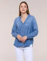 Camisa confeccionada en tela tencel azul, de estilo casual y silueta semi holgada. Presenta cuello camisero tradicional, abotonadura frontal completa, dos bolsillos superiores en el pecho y mangas largas con presilla y botón para arremangar.