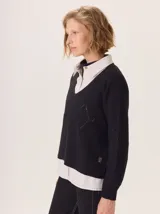 Buzo de lana color marrón topo, con cuello en V y diseño de punto calado en rombos en el frente y mangas.