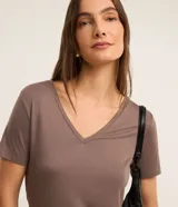 Blusa básica de manga corta con cuello en V, confeccionada en tejido de viscosa con elastano. Presenta un diseño liso y corte ajustado.