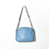 Bandolera celeste de cuero sintético con correa larga regulable de cinta tejida.