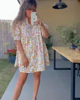 Vestido corto verde con estampado floral, cuello alto, mangas cortas abullonadas y corte holgado.