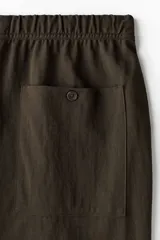 Pantalón marrón de corte regular fit en mezcla de algodón, con cintura elástica y cordón de ajuste, bolsillos al bies y piernas rectas.