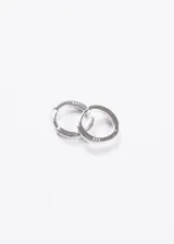 Par de aros tipo huggies de plata 925, con forma ovalada y engaste continuo de zirconias brillantes en el frente.