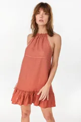 Vestido corto verde militar de lino, con escote halter fruncido en el cuello y detalle de volados en el ruedo.